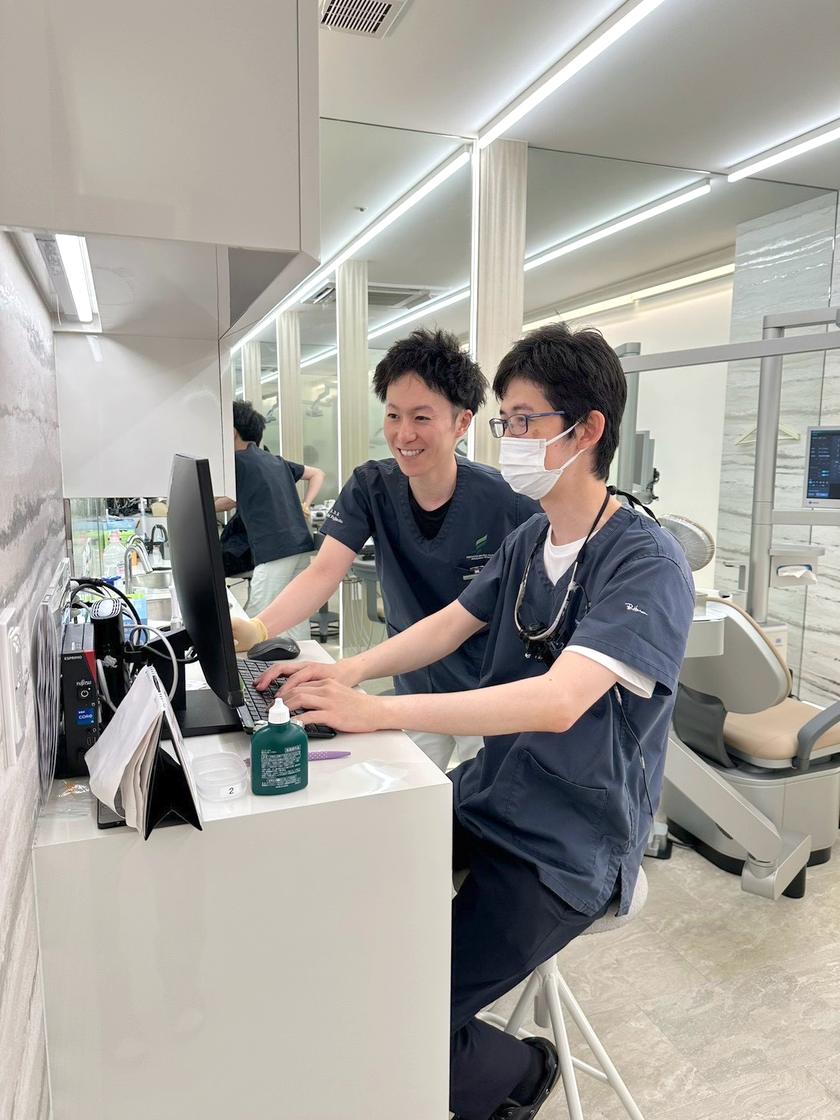 パソコンで情報を確認する歯科医師