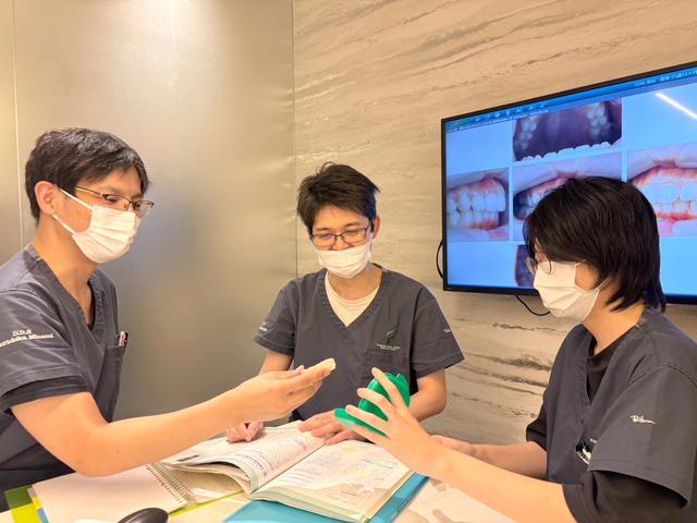 症例写真を見ながら勉強する歯科医師